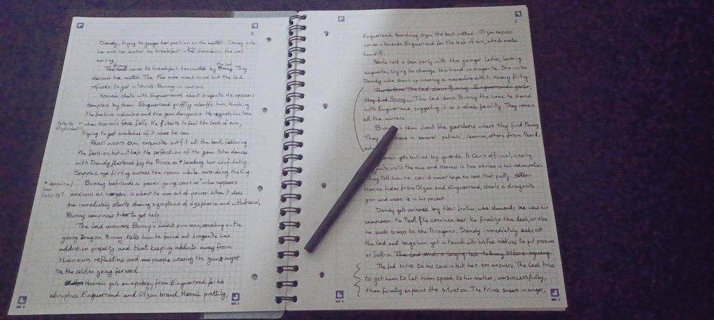 An open notebook covered in handwriting with a pen laying on it.
